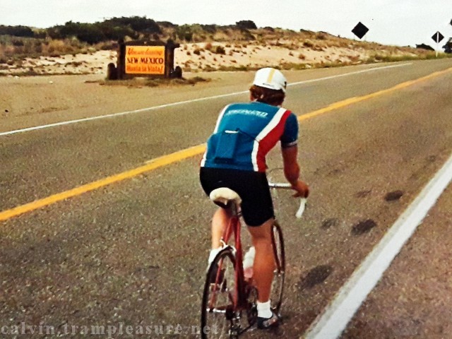 Calvin on his bike with "Entering New Mexico" sign in the background