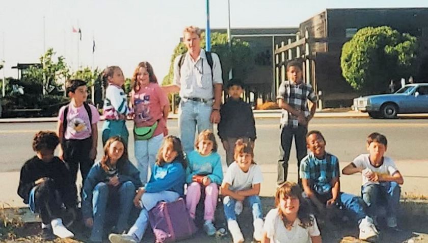 Photo of students and teacher in front of a garden.